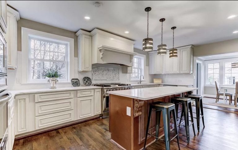 Modern kitchen with cream cabinets, wood island, pendant lighting, and stainless steel appliances