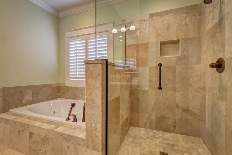 Luxury bathroom with travertine tile shower enclosure, soaking tub, and glass door frameless design