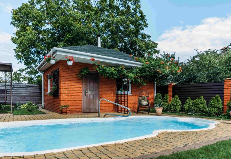 Modern orange brick ADU with pool, patio decking, and surrounding vegetation