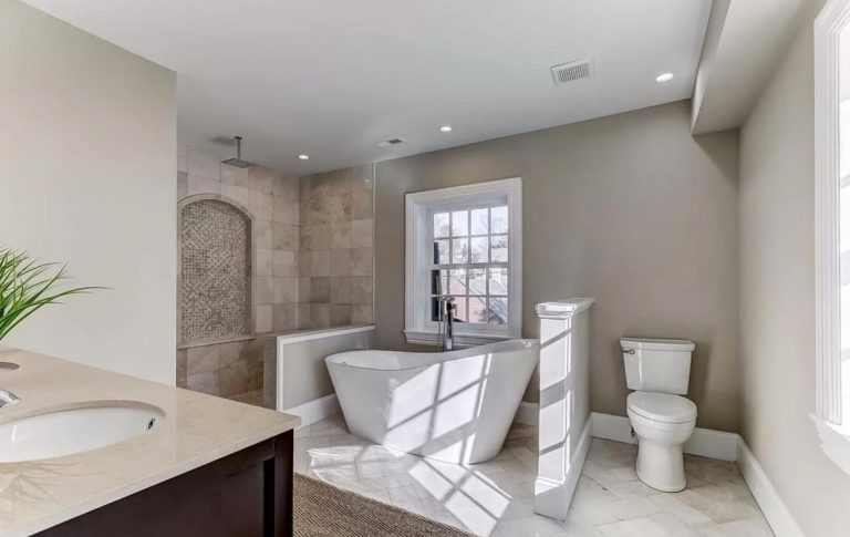 Modern bathroom with freestanding bathtub, walk-in shower, double vanity, and white subway tile flooring