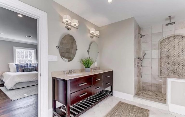 Modern bathroom with dark wood vanity, vessel sink, wall sconces, and walk-in shower with tile surround